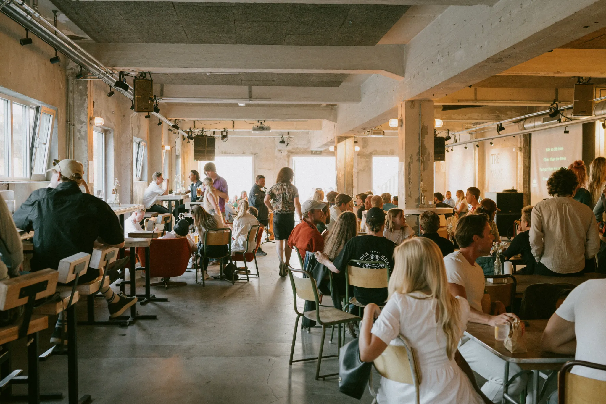 Guests filling a busy restaurant and bar in a former factory hall