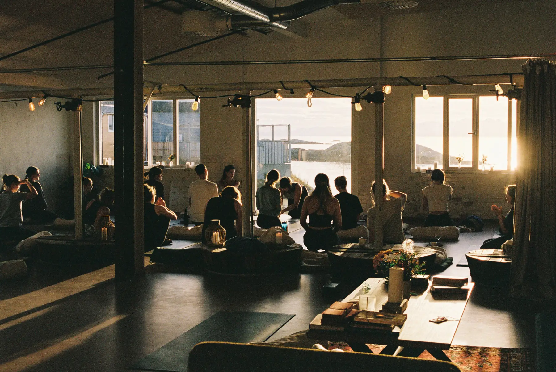 A yoga class in the factory hall, evening sun through the windows