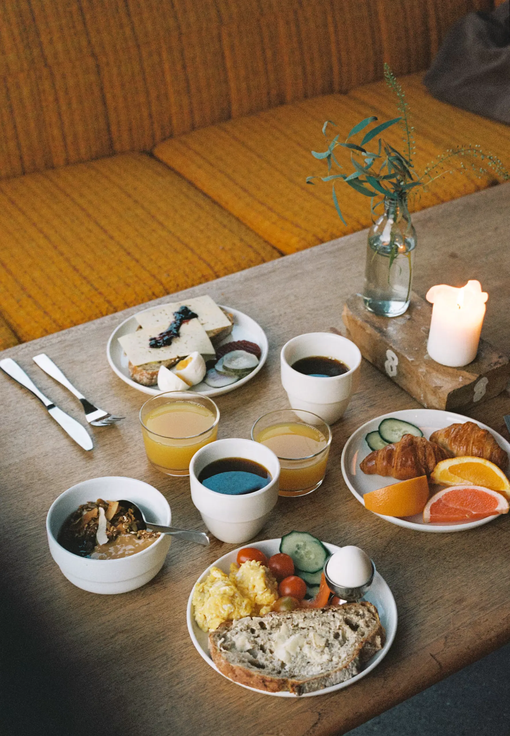 Breakfast on a wooden table, with coffee, juice and pastries