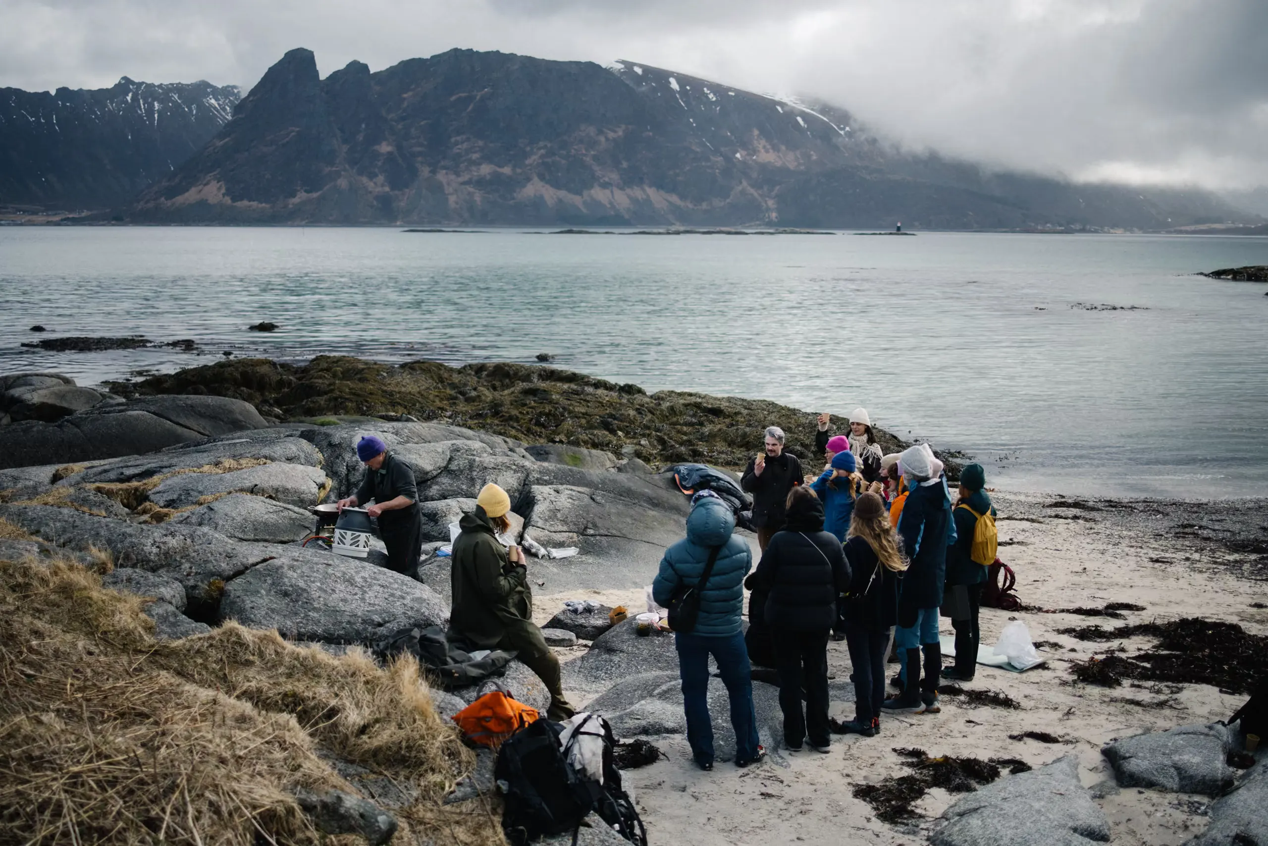 A guide leading a group along a rocky shore by the sea